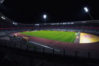 Stade de football éclairé pendant une rencontre de soirée